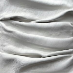 White fabric with soft folds creating an elegant texture and appearance, ideal for backgrounds.