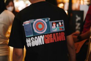 An individual in a #SonyCreator shirt at a bustling indoor event.